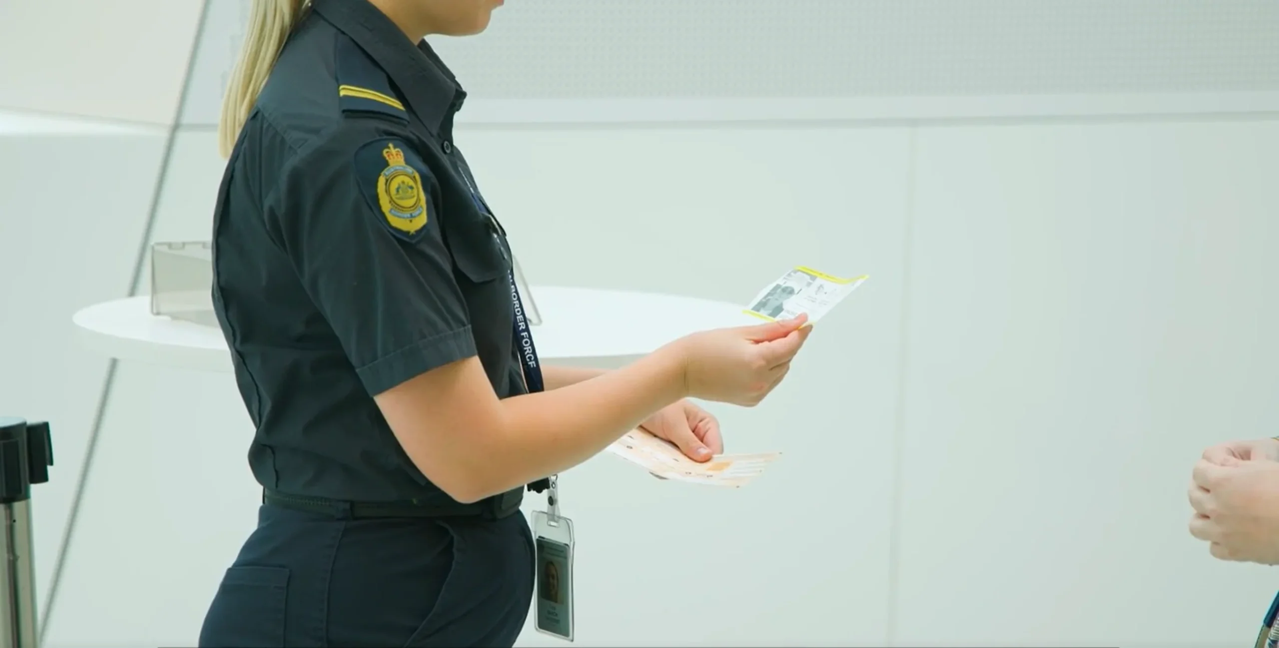 澳洲边境力量ABF官员在出口核对SmartGate小票和入境卡的实拍画面,截自ABF官方SmartGate入境流程说明视频
